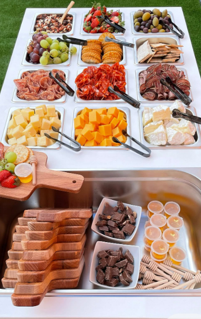 Outdoor food platter with various snacks and fruits on a white tray.